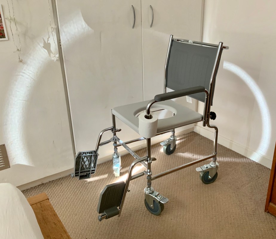 Shiny chrome commode casting light onto bedroom walls.