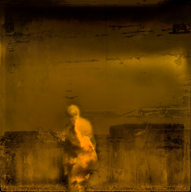 Yellow and black image of a figure of a person, with clouds within the outline of the person. The background is dark and barren.